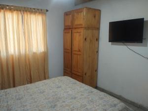 a bedroom with a bed and a dresser with a television at Casa doña tati in Cortaderas