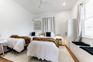 Un dormitorio con dos camas y un escritorio y una ventana. en Urban Getaway Ipswich W Cottage, en Ipswich