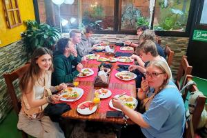 a group of people sitting at a table eating food at Cabinas El Pueblo B&B Monteverde in Monteverde Costa Rica