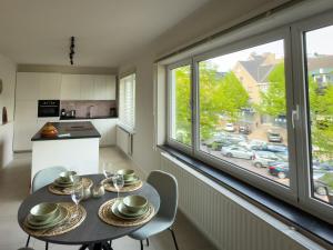 a kitchen with a table and chairs and a large window at Genk Central Apartment in Genk