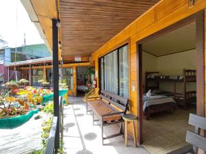 a porch with a wooden bench and a bedroom at Cabinas El Pueblo B&B Monteverde in Monteverde Costa Rica