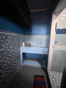 a bathroom with a sink and a blue wall at Kasuari Homestay by Ipoeng RB&B in Telaga