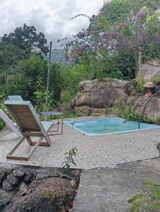 a chair sitting next to a small swimming pool at Finca Santa María Del Lago in Piedecuesta