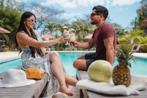 a man and woman drinking cocktails by the pool at Hotel La Estacion in Granada