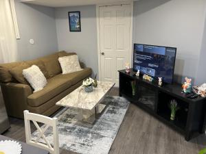 a living room with a couch and a flat screen tv at Beautiful and cozy unit in Mississauga
