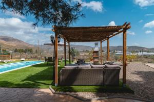 a gazebo with a seating area next to a pool at Cortijo Pinar 2 in Níjar