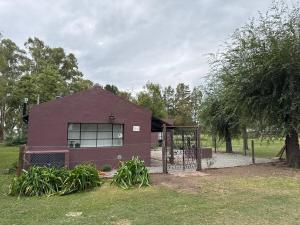a purple building with a gate in a field at El Rancho - Hospedaje Rural in Navarro