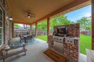 un patio al aire libre con un horno de ladrillo y una mesa en Modern 4BR Retreat, Hot Tub, Game Room near DFW, en Irving