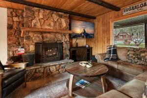 ein Wohnzimmer mit einem Steinkamin in einer Hütte in der Unterkunft Little Red Cabin with a Hot Tub BBQ plus large Yard in Sugarloaf