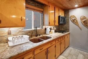 eine Küche mit Holzschränken und einer Spüle in der Unterkunft Little Red Cabin with a Hot Tub BBQ plus large Yard in Sugarloaf + 25 Fotos