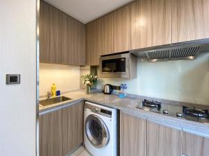 a kitchen with a washing machine and a microwave at Tyms APT Hengshan RD Near IAPM K11 Line9 in Shanghai