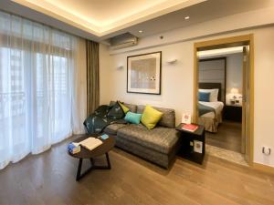 a living room with a couch and a bed at Tyms APT Hengshan RD Near IAPM K11 Line9 in Shanghai