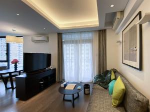 a living room with a couch and a flat screen tv at Tyms APT Hengshan RD Near IAPM K11 Line9 in Shanghai