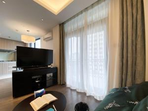a living room with a tv and a large window at Tyms APT Hengshan RD Near IAPM K11 Line9 in Shanghai