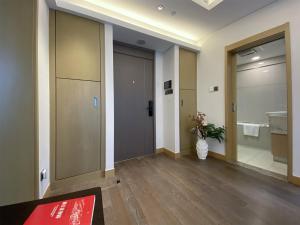 a hallway with a door and a vase of flowers at Tyms APT Hengshan RD Near IAPM K11 Line9 in Shanghai