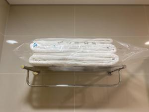 a stack of towels on a rack in a bathroom at Tyms APT Hengshan RD Near IAPM K11 Line9 in Shanghai