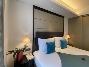 a hotel room with a large bed with blue pillows at Tyms APT Hengshan RD Near IAPM K11 Line9 in Shanghai