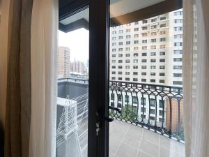 a door to a balcony with a view of a building at Tyms APT Hengshan RD Near IAPM K11 Line9 in Shanghai