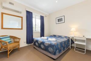 
a bedroom with a bed and a desk at Blue Gum Hotel in Hornsby
