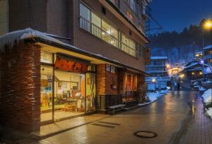 藏王温泉Yoshidaya的夜晚街道边的一栋建筑