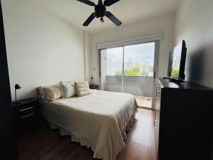 Un dormitorio con una cama y un televisor de pantalla plana. en Praga, amplio y luminoso, en La Plata