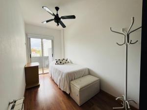 Un dormitorio con una cama y un ventilador de techo. en Praga, amplio y luminoso, en La Plata