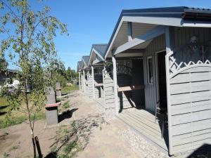 Une rangée de maisons blanches avec terrasse couverte dans l'établissement Holiday Home in Dziwnówek by Baltic Sea, à Dziwnówek