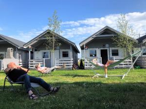 un groupe de personnes assises sur des chaises de jardin dans l'établissement Holiday Home Dziwnówek near Baltic Sea, à Dziwnówek
