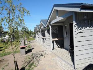 Une rangée de maisons blanches avec terrasse couverte dans l'établissement Holiday Home Dziwnówek near Baltic Sea, à Dziwnówek