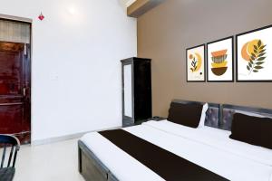 een slaapkamer met een bed met zwarte en witte lakens bij Hotel O IIDM ECO CENTRE in Lucknow +27 foto's