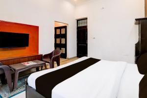 een hotelkamer met een bed en een tv bij Hotel O IIDM ECO CENTRE in Lucknow