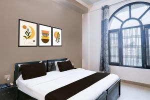een slaapkamer met een groot bed en een raam bij Hotel O IIDM ECO CENTRE in Lucknow
