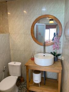 a bathroom with a sink and a toilet and a mirror at Yohana Cottage in Tual