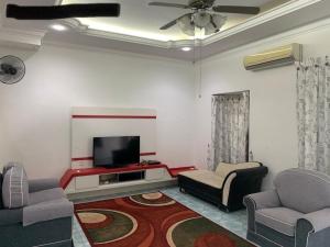 a living room with two chairs and a flat screen tv at Thind place in Kamunting