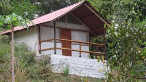 a small house with a red roof in the woods at HOSTAL MIRADOR dentro del parque tayrona in El Zaino
