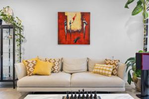 珀斯Stylish Mount Lawley Retreat Walk to Beaufort Street的客厅里有一张沙发，墙上挂着一幅画