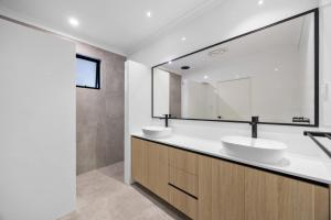 珀斯Stylish Mount Lawley Retreat Walk to Beaufort Street的配有两个水槽和一面大镜子的浴室