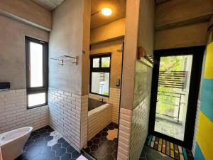 ein Badezimmer mit Badewanne und Toilette und einem Fenster in der Unterkunft Hillside Beautiful House in Taitung + 13 Fotos