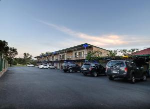 a parking lot with cars parked in front of a building at Centrepoint Midcity Motor Inn in Warwick