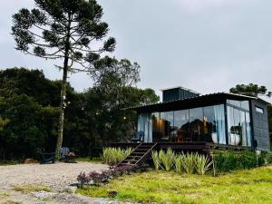 a glass house sitting on top of a field at Cabana Black BIRD l, morro da igreja Urubici SC in Urubici
