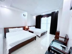 a hotel room with two beds and a desk at Đức Thắng Hotel in Sầm Sơn +26 photos