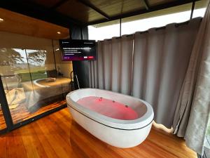 a bath tub sitting in a room with a television at Cabana Black BIRD l, morro da igreja Urubici SC in Urubici +37 photos