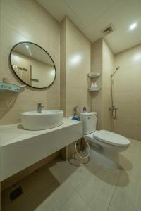 a bathroom with a sink and a toilet and a mirror at Domi Homestay Nera Garden Huế in Thôn Văn Dương