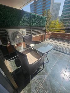 a patio with two chairs and a table on a balcony at San Ignacio Suite Apoquindo MQ3 in Santiago
