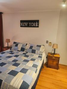 a bedroom with a bed and a new york sign on the wall at San Ignacio Suite Apoquindo MQ3 in Santiago