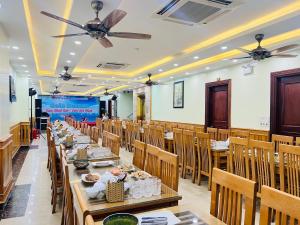 a dining room with long tables and chairs at Đức Thắng Hotel in Sầm Sơn