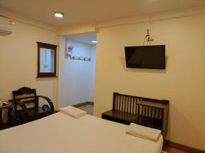 a room with a table and a tv on the wall at Erawan in in Mae Sot