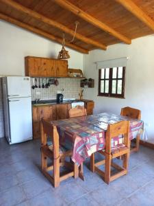 a kitchen with a table and chairs and a refrigerator at das gelbe haus in Los Reartes