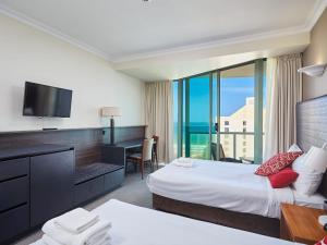 a hotel room with two beds and a desk and a television at Twin beds room with a great view in Heart of GC in Gold Coast
