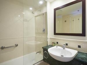 a white bathroom with a sink and a shower at Twin beds room with a great view in Heart of GC in Gold Coast +3 photos